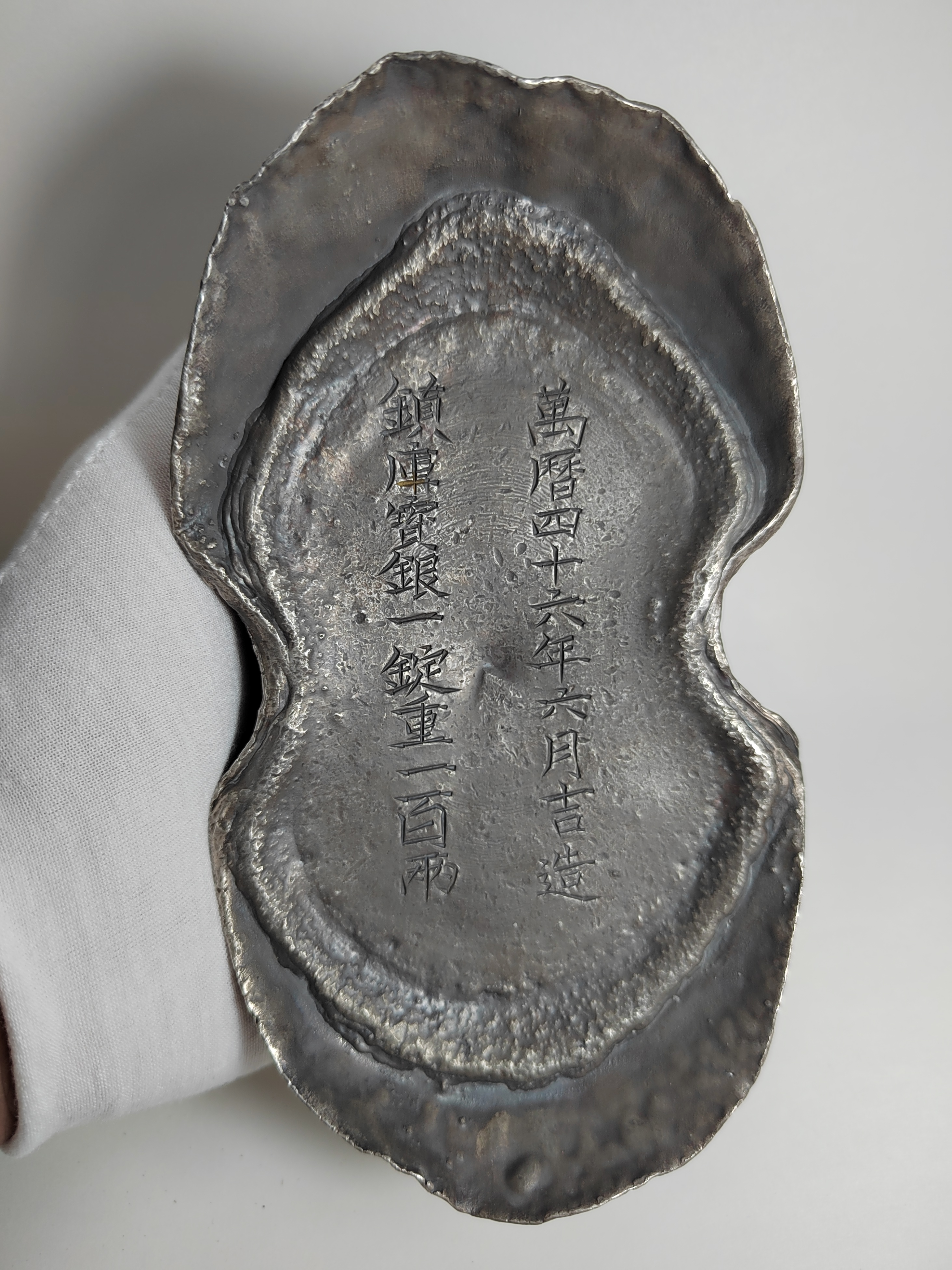 Ming Wanli period One hundred taels of silver ingot inscribed with "Treasure silver for guarding the treasury made in June of the forty-sixth year 